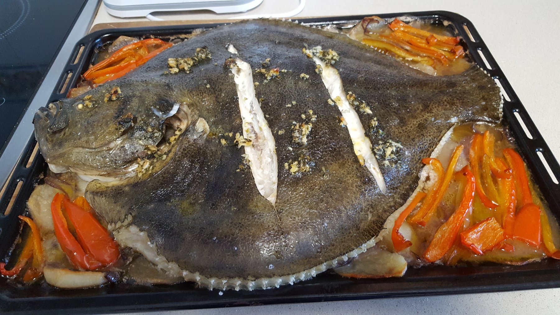 Whole roast turbot on a roasting tray