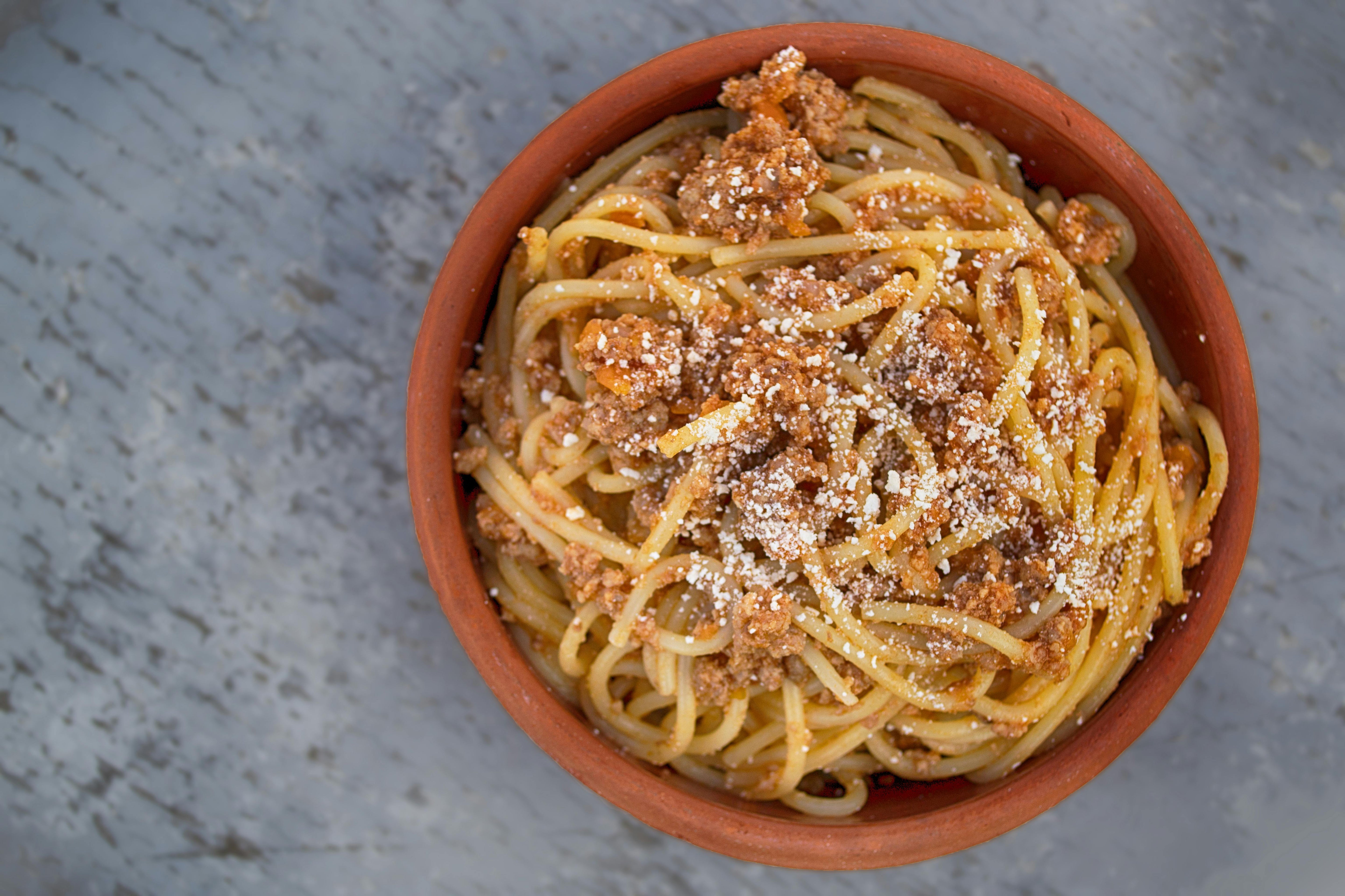 Bowl of spaghetti with meat sauce and grated cheese