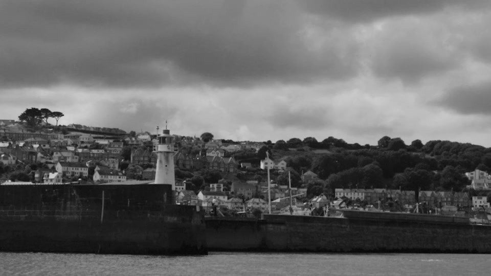 Black and white photograph of a harbour where the boats come in