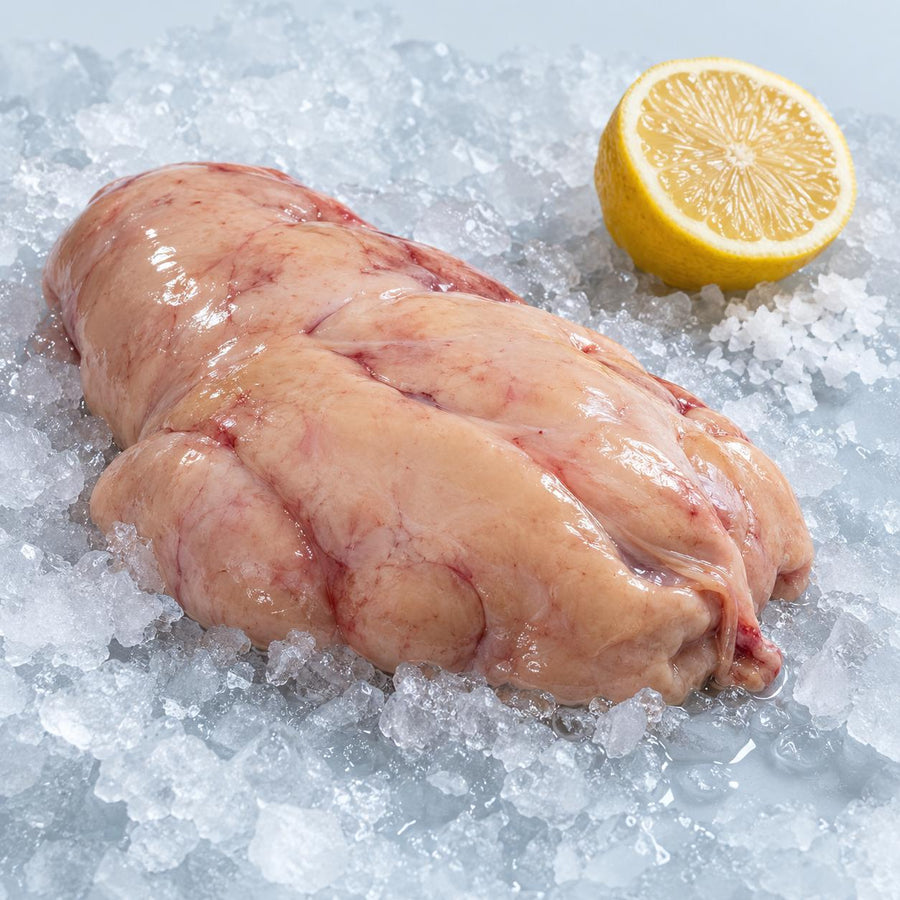 A raw monkfish liver on crushed ice with half a lemon