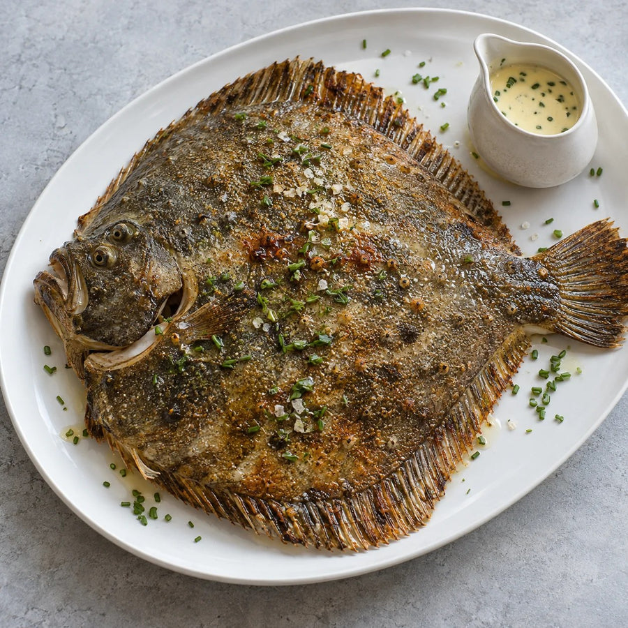A whole roast turbot with chives and a jug of hollandaise